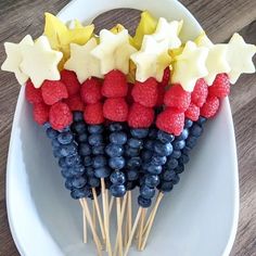 a plate with berries and stars on sticks