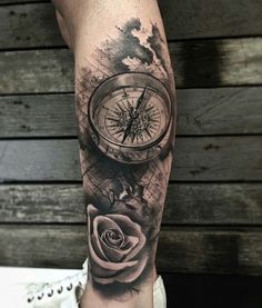 a man's leg with a compass and rose tattoo on the side of his arm