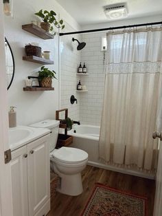 a bathroom with white walls and wooden floors