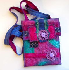 a colorful purse with flowers and buttons on the front is sitting on a white surface