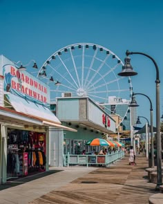 the boardwalk is lined with shops and ferris wheel