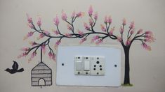 an electrical outlet with pink flowers painted on it and a bird flying over the wall