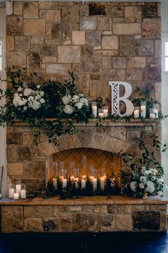 the fireplace is decorated with candles and flowers