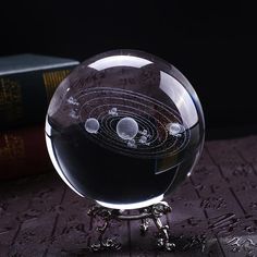 a glass ball with an image of the solar system in it on top of a table