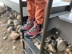 a person wearing orange pants and red shoes standing on a metal step