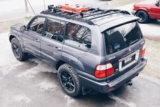 an suv parked on the side of the road with skis strapped to it's roof