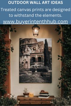 an outdoor wall art is displayed on the wall above a table with books and plants