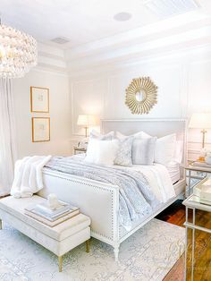 a bedroom with white furniture and chandelier