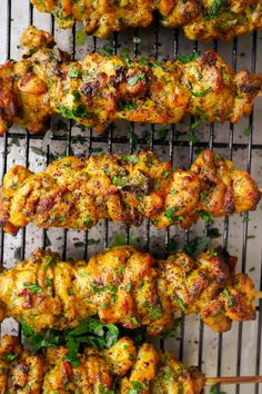 chicken kebabs on a grill with parsley