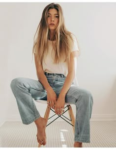 a woman sitting on top of a chair with her legs crossed