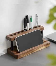 a wooden desk organizer with pens and pencils