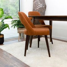 an orange chair sitting in front of a wooden table with potted plants on it