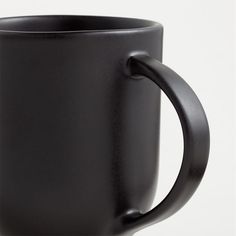 a black coffee mug is shown on a white background with the handle pointing up to the side