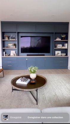 a living room filled with furniture and a flat screen tv mounted on a wall above a coffee table