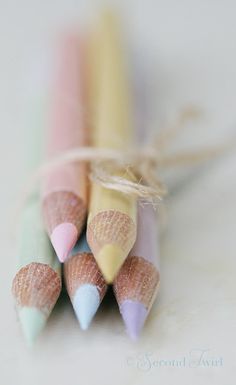 four pastel colored pencils are tied together