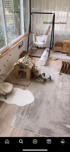 a room with a hammock and other items on the floor in front of a window