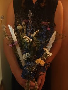 a woman holding a bunch of flowers in her hands