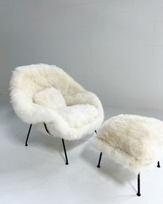 a white chair and ottoman sitting next to each other on top of a white floor