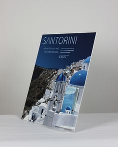 the front cover of a magazine with white buildings and blue domes on it's sides