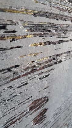 an abstract photograph with gold and silver streaks on it's surface, as well as the background