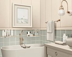 a white bath tub sitting next to a sink under a framed picture on the wall