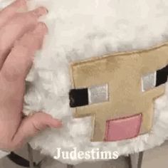 a person holding a stuffed sheep with their hands