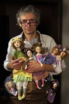 a man holding many dolls in his hands