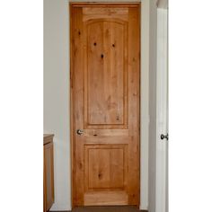 a wooden door in the corner of a room with carpet on the floor and walls