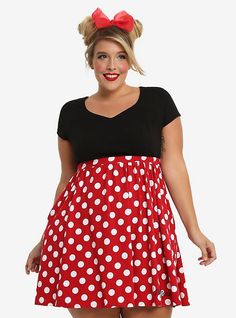 a woman wearing a red and white polka dot dress with minnie mouse ears on her head