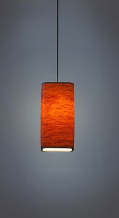 a wooden light hanging from a ceiling fixture with an orange shade on it's side