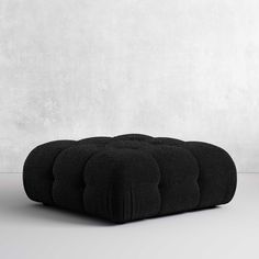 a black cushion sitting on top of a white floor