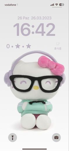 the hello kitty doll is wearing headphones and sitting on top of a white phone