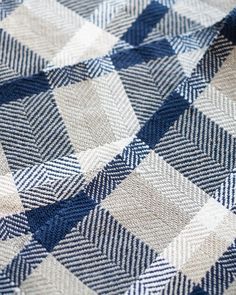 a blue and white checkered blanket is laying on top of a tablecloth that has been folded over