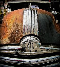 an old rusted out truck is parked in a garage