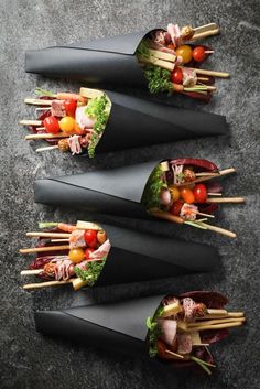 four different types of skewers with vegetables and meats on them sitting on a table