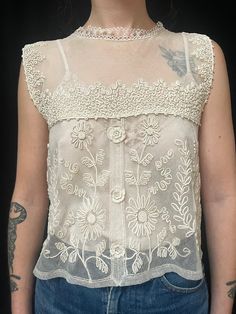 Item Details. From France C1930s this pretty and romantic lace camisole top which is covered in patterned of applied silk braid which has been stitched in decorative patterns (soutache) This lovely too would look great with jeans as shown in our photos or with a skirt or smart trousers for a more dressy look. The blouse fastens down the centre back with tiny hidden poppers. Measurements: All taken whilst garment is laying flat. Our model Amie is a UK size 8. Across front 43cm (17 inches) Length from shoulder to hem 49cm (19.5 inches) Condition. In excellent wearable condition.  All of our specially chosen pieces are antique and have the idiosyncrasies of antique and loved garment so small marks, stains and signs of wear are to be expected and are an inherent part of their charm and history Vintage Beige Crochet Lace Top, Vintage Crochet Top Beige Summer, Vintage Crochet Top In Beige For Summer, Vintage Beige Crochet Top For Summer, Vintage Beige Lace Crochet Top, Fitted Lace Crochet Camisole Top, Spring Vintage Lace Crochet Top, Vintage Cream Lace Crochet Top, Fitted Bohemian Lace Top For Daywear