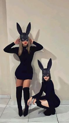 two women in bunny ears are posing for the camera, one is wearing a rabbit mask