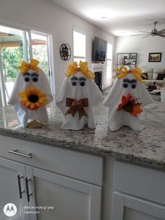 three white ghost decorations sitting on top of a kitchen counter