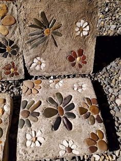 four stone blocks with flowers and leaves painted on the rocks in different colors, shapes and sizes