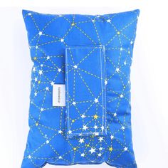 a blue pillow with white stars on it and a tag hanging from the front pocket