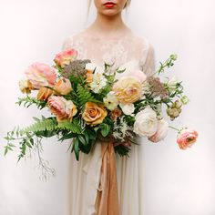 a woman holding a bouquet of flowers in her hands