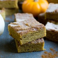 pumpkin spiced brownies stacked on top of each other in front of small pumpkins