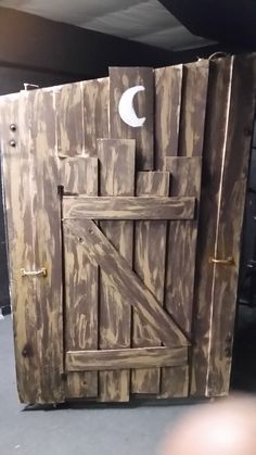 an old wooden door with a crescent on the top and bottom panel is made out of wood