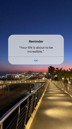 a long walkway leading to the beach at night with a quote above it that reads reminder your life is about to be incredible