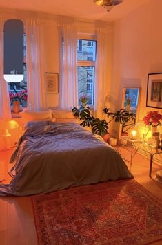 a bed sitting in a bedroom next to two windows with candles on each side of it