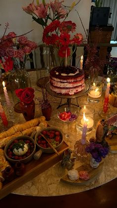 a table topped with lots of different types of food and candles on top of it