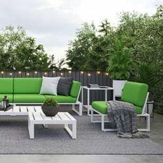 a green and white couch sitting on top of a patio next to a wooden table