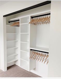 an organized closet with white shelving and wooden hangers