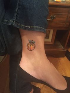 a small pumpkin tattoo on the ankle