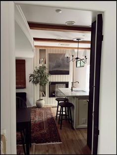 an open door leading to a kitchen and dining room with bar stools in it